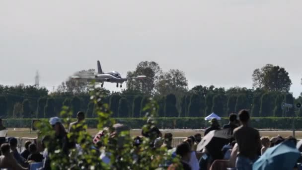 Modern jet trainer plane lands during an airshow with audience that admires it — Stock Video