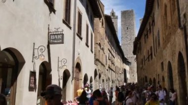 Güneşli bir günde San Gimignano 'nun eski sokaklarında yürümek