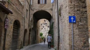San Gimignano 'da eski tuğladan evler olan dar bir ortaçağ sokağı.