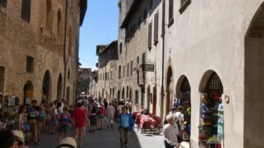 San Gimignano 'nun tarihi merkezinde güneşli bir yaz gününde bir grup turist..