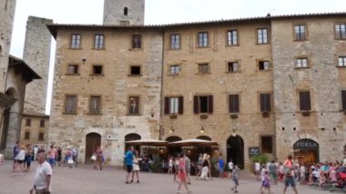 Turistler San Gimignano 'nun tarihi merkezindeki Piazza della Cisterna' ya akın ediyorlar.