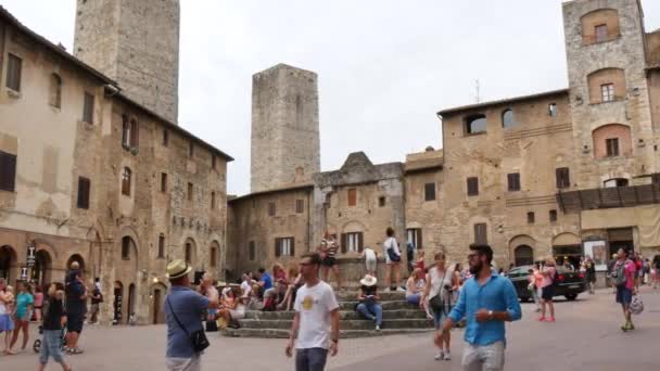 Turistit lähistöllä Piazza della Cisterna San Gimignano — kuvapankkivideo