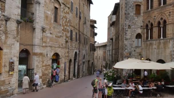 I turisti mangiano in un ristorante lungo una delle vie del centro di San Gimignano — Video Stock