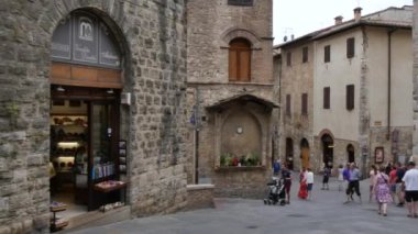 Turistler San Gimignano Toskana 'nın antik caddelerinde yürürler.