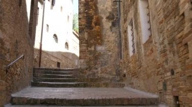Bir ortaçağ kasabasında antik merdivenleri tırmanıyor.