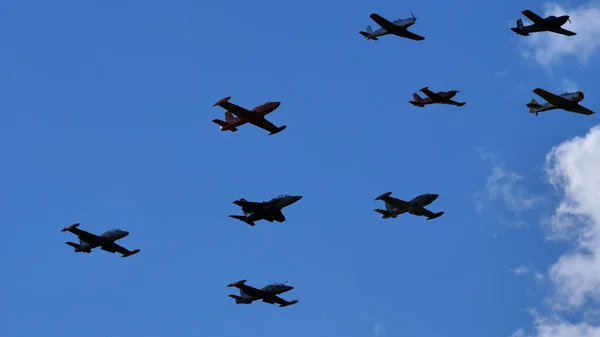 Mavi gökyüzünde uçmakta olan bir grup askeri uçak. Pervaneler ve jetler — Stok fotoğraf