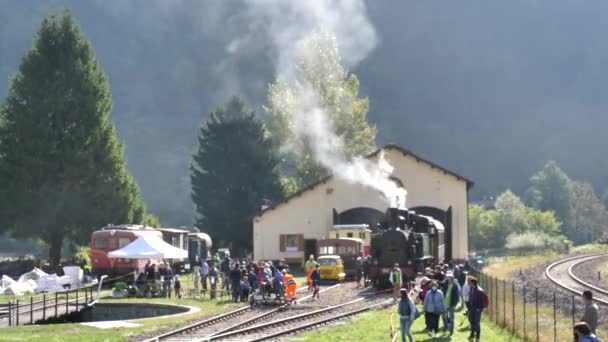 Touristengruppe mit alter Dampflokomotive im Bahnhof — Stockvideo