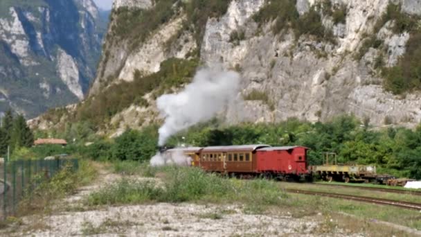 Vieja locomotora de tren de vapor tirar de tres vagones rojos en las montañas — Vídeo de stock