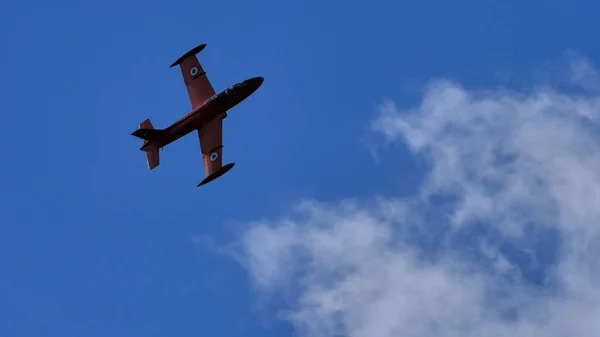 Retro katonai sugárhajtású repülőgép gurul a kék égen egy repülőnap alatt. — Stock Fotó