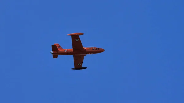 Avion à réaction historique militaire orange en vol dans un ciel parfaitement bleu — Photo