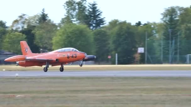 Historisches militärisches Schulungsflugzeug mit weithin sichtbarer oranger Farbe landet — Stockvideo