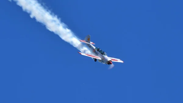 Metallic aluminium vliegtuig met rook naar beneden in de blauwe lucht. Kopieer ruimte. — Stockfoto