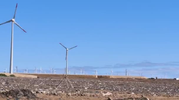 Het passeren van windturbines in een verlaten gebied waar hernieuwbare energie wordt geproduceerd — Stockvideo