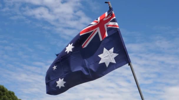 Australië vlag zwaaiend in de wind in slow motion. Close up view met blauwe lucht achtergrond — Stockvideo