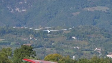 Modern planör bir hava gösterisi sırasında çim havaalanına iniyor.