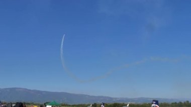 Küçük pervaneli akrobatik uçak beyaz duman iziyle yarım Küba sekizi yapıyor.