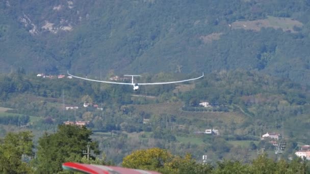 Un planeur moderne atterrit sur un terrain d'aviation en herbe lors d'un spectacle aérien — Video