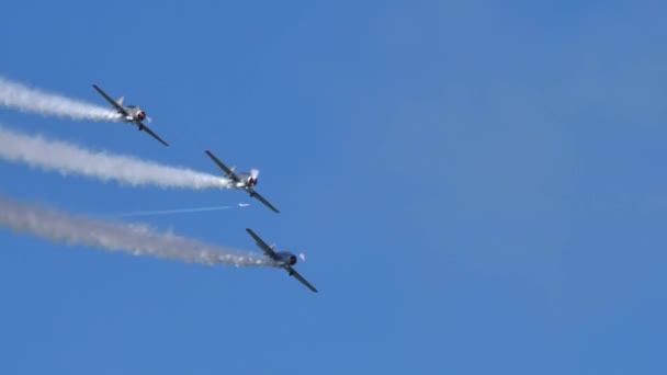 Drie historische aërobe vlakken voeren lus in dichte formatie in de blauwe lucht uit — Stockvideo