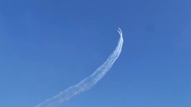 Aerobatik uçaklar mavi gökyüzünde beyaz duman izleriyle bir döngü çiziyor.