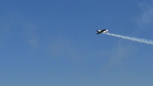 El avión vuela a gran velocidad y luego sube para dibujar un gran círculo en el cielo azul — Vídeos de Stock