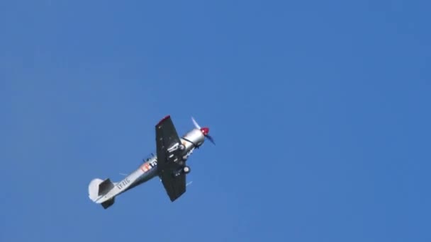 Aerobatic metallic gray color plane performs a barrel roll in the blue sky — Stockvideo