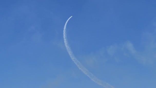 Airplane draws a large circle in the blue sky with its white smoke — ストック動画