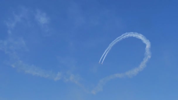 Yakovlev Yak-52 planes draw circles in blue sky by performing a looping sequence — стоковое видео