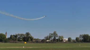Akrobatik uçak mavi gökyüzünde beyaz dumanla bir çember çizer