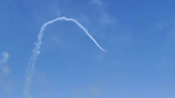 Aerobatic airplane does an half cuban eight with white trail in blue sky — 图库视频影像