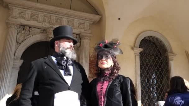 Pareja en traje de período de pie contra la construcción durante el carnaval de Venecia — Vídeos de Stock