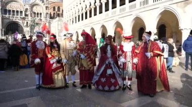 Kültürel kırmızı karnaval elbiselerinde, turistler arka planda. 