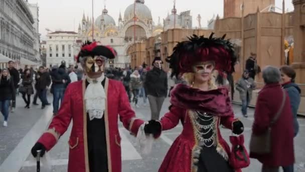 Una pareja con máscaras y disfraces venecianos en la Plaza de San Marcos Venecia, Italia — Vídeos de Stock
