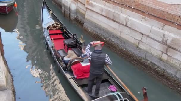Gondolcu turistleri bir gondolla Venedik, İtalya 'daki dar bir kanala götürüyor. — Stok video