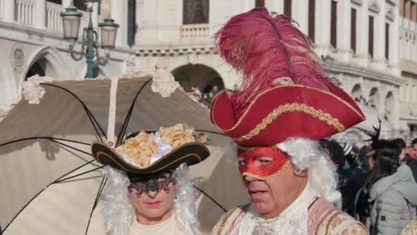 Een koppel met kleurrijke maskers in kostuums tijdens het Venetiaanse carnaval — Stockvideo