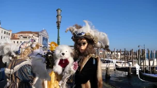 En flicka i venetiansk kostym med sin hund i Saint Marks Square - Venedig Karneval — Stockvideo