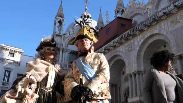 Ένα ζευγάρι με φανταστικά βενετσιάνικα κοστούμια στην πλατεία St Marks κατά τη διάρκεια του καρναβαλιού — Αρχείο Βίντεο