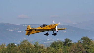 Siyah uçlu sarı küçük ekstrem pervaneli akrobatik uçak kalkıyor.