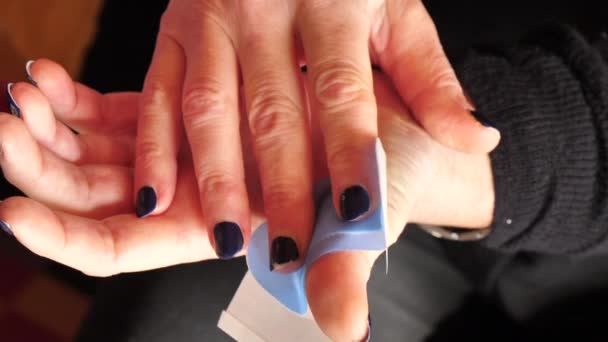 Vrouw brengt een pleister op haar duim schillen van een pleister en wikkelt rond — Stockvideo
