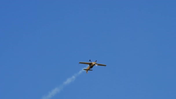 Vliegtuig voert verbazingwekkende aerobatics flips vrijgeven aerobatics rook van achteren — Stockvideo