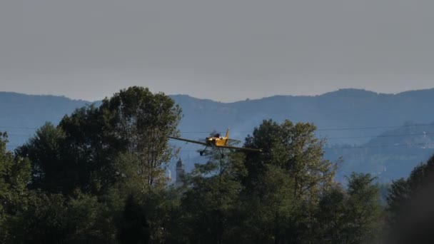 Kleine gele vliegtuigen landen op de baan beweegt met snelheid op het groene veld — Stockvideo