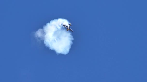 Avión hace círculos de humo en el cielo durante acrobacias acrobáticas acrobacias acrobacias — Vídeos de Stock