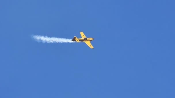 Stunt avión realiza acrobacias en el cielo azul claro en cámara lenta — Vídeos de Stock