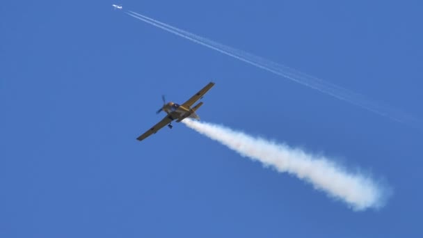 Kleines gelbes Flugzeug führt Akrobatik gegen den klaren Himmel in Zeitlupe auf — Stockvideo