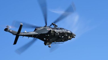 Mavi gökyüzünde uçan askeri helikopter aşağıdan görüldü.