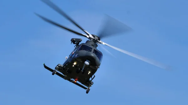 Сучасний військовий вертоліт у польоті на передньому плані синього неба. — стокове фото