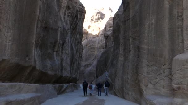 Turistas caminham pela entrada principal Siq que leva à cidade de Petra Jordan — Vídeo de Stock