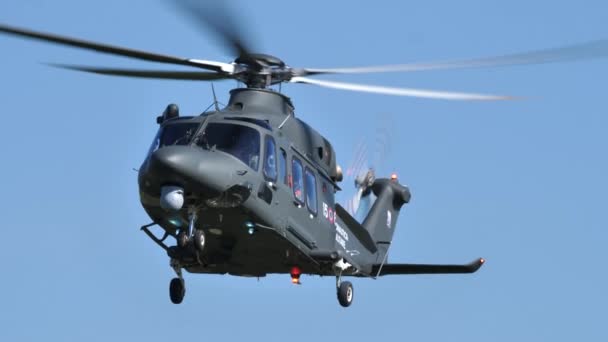 Военный вертолет в стационарном полете в голубом небе солнечного дня — стоковое видео
