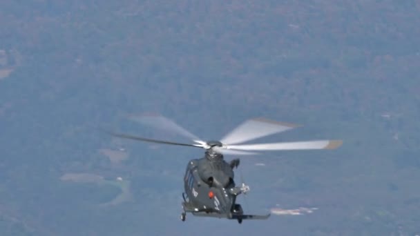 Katonai helikopter felmászik függőlegesen nagy sebességgel a kék égen — Stock videók