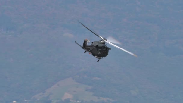 Helikopter in lage hoogte vlucht met hoge snelheid met bergen op de achtergrond — Stockvideo