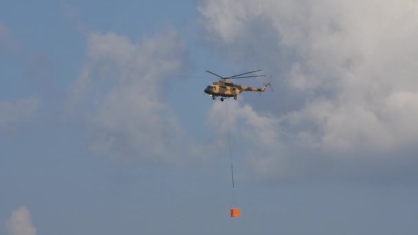 Russische camouflage militaire helikopter vliegt een oorlog belasting op de barycentrische haak — Stockvideo